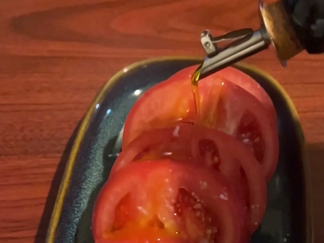 スライスしたトマトにEVOOをひと回しかける